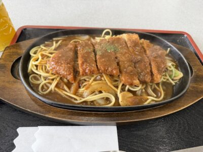 鉄板に乗ったナポリタンの上にカツレツが乗っている料理